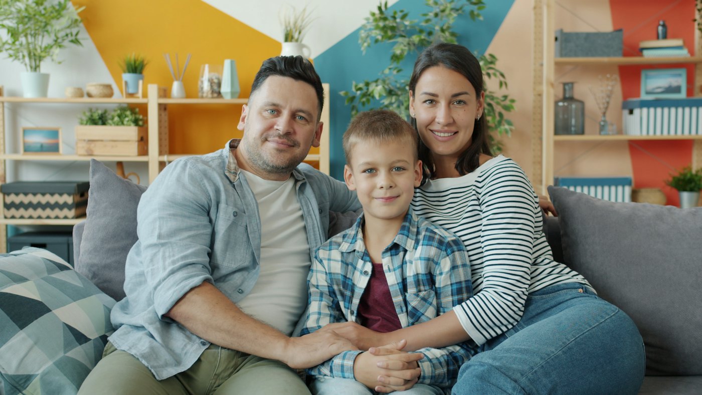 Eine Familie sitzt zusammen auf dem Sofa